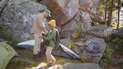 little boy and dad setting up tent at campsite