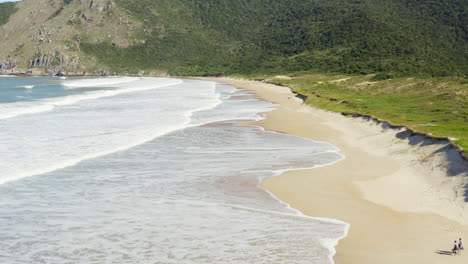 vista aérea cerca de la arena de una pareja caminando en la playa, playa lagoinha do leste, florianópolis, santa catarina, brasil