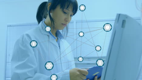 animation of network of medical icons over asian female scientist working at laboratory computer