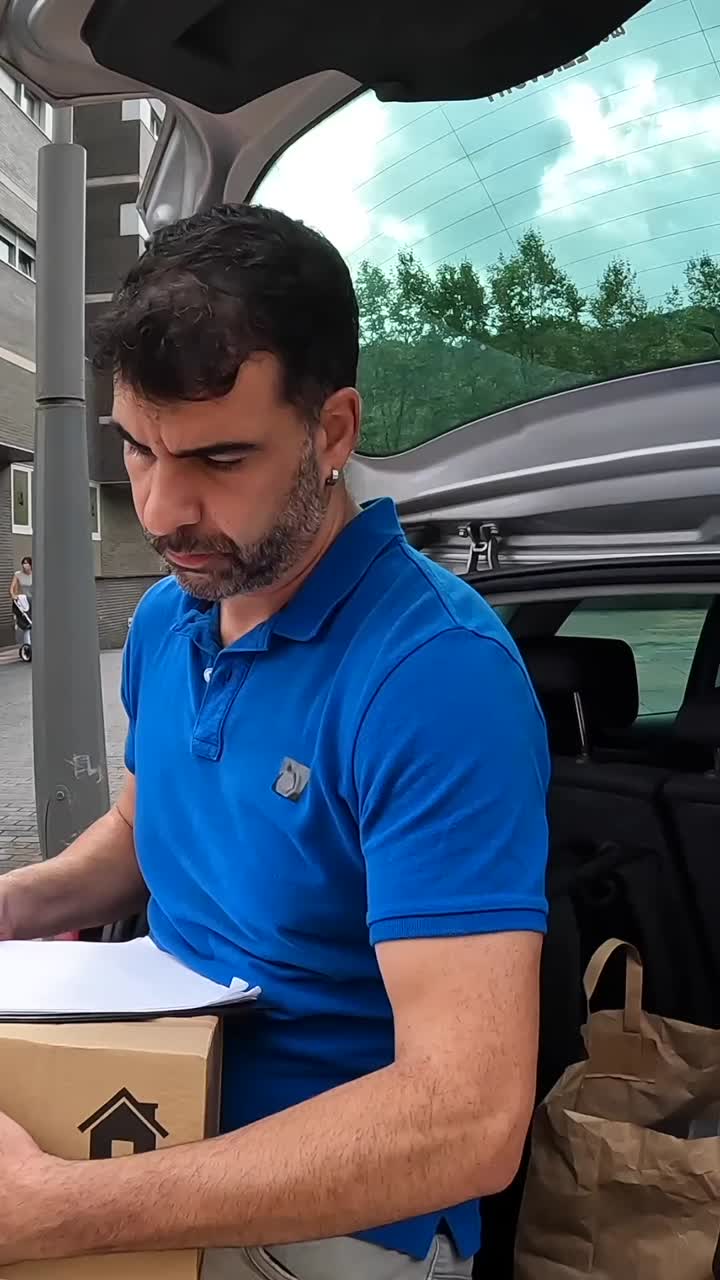 Hombre cargando cajas en el maletero del coche