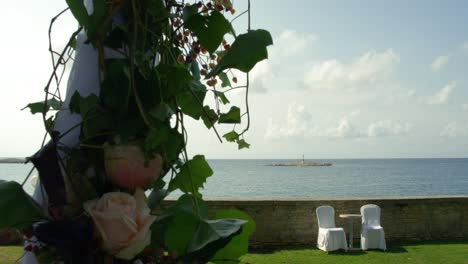 decorated wedding ceremony outside with fresh flowers and sea view