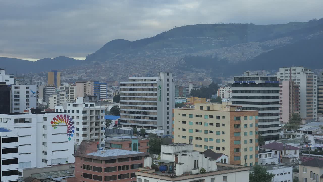 Nuvole che passano sul terreno collinare che circonda i grattacieli di Quito, Ecuador, al mattino, timelapse