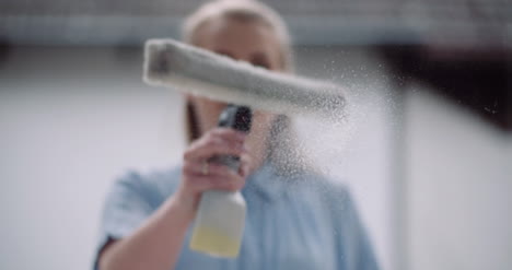 cleaning woman cleaning window with detergents