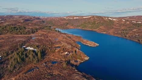 dried terrain by the shores of reinsjoen lake in norway. aerial descending shot