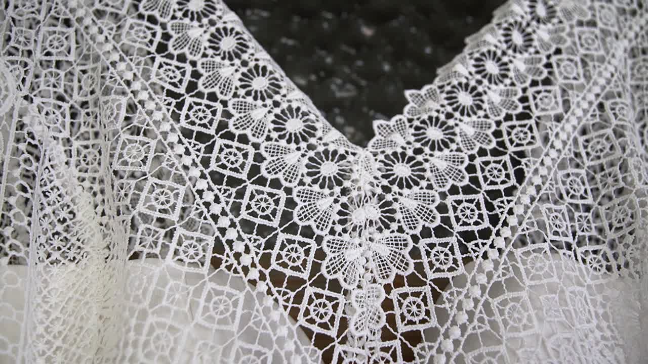 Close up wedding dress details of collar hanging on beautiful wooden door