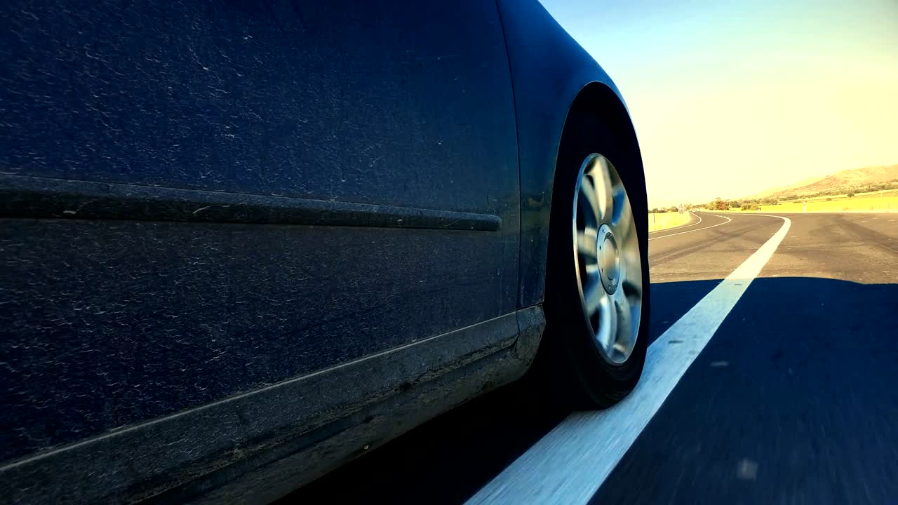 car goes on bilateral road on sunset, sunrise low angle highway race