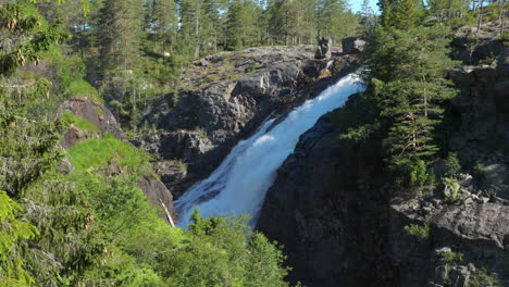 rjukan falls, or rjukanfossen waterfall, in alpine forest of norway