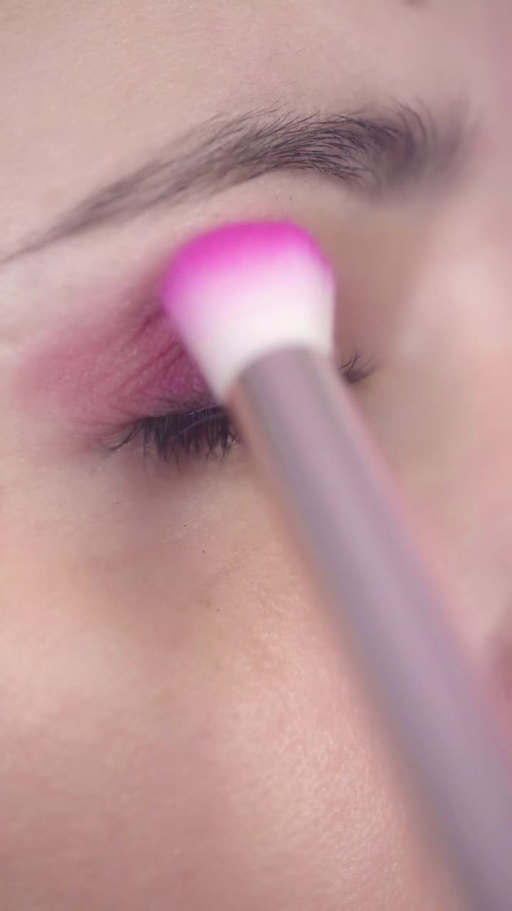 Close-up of Woman's Eye Applying Pink Eyeshadow with Brush