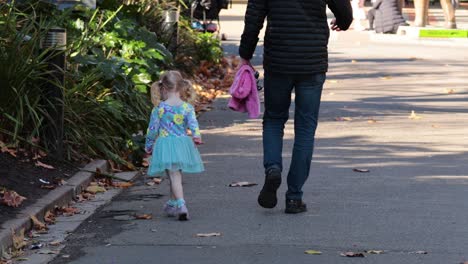 a father and daughter walk together at the zoo