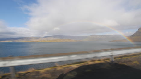 Arco-Iris-A-Lo-Largo-De-Una-Carretera-Costera-En-Islandia.-Vista-Desde-Un-Auto