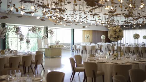 lavish wedding reception venue with grand floral centerpieces and intricate ceiling décor