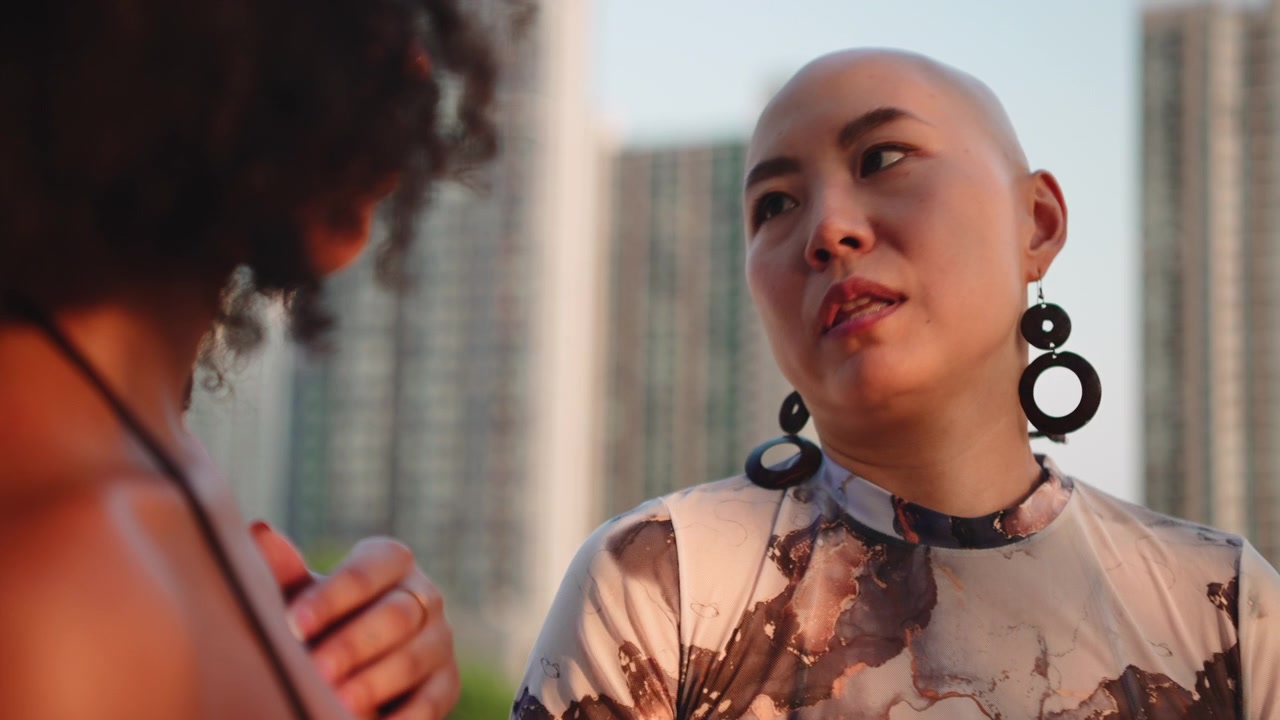 Two Women Having an Engaging Conversation Outdoors at Sunset