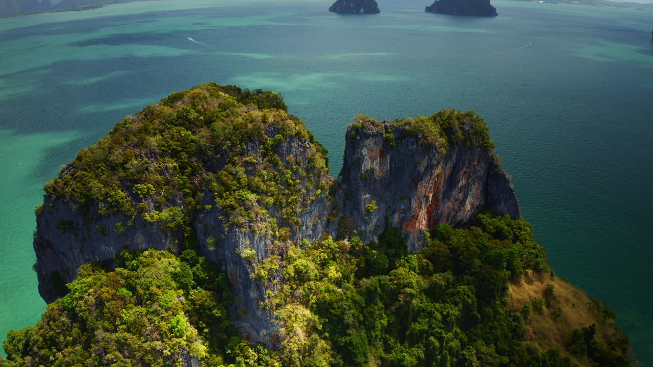 vuelo sobre formación rocosa cubierta de verde en la isla de tailandia
