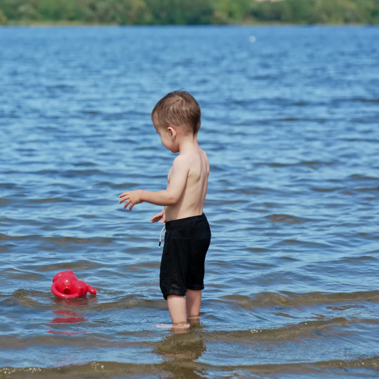 Child playing on a river beach. Summer water pond playground