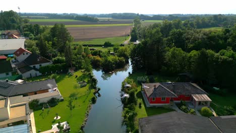 idyll view of a small countryside village near river stream and fields