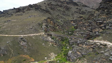 aerial, outdoor biking bridge trail connecting mountain valley, rocky cliffs