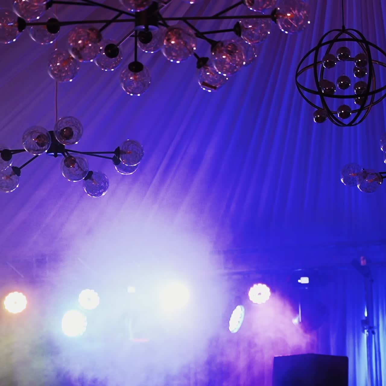 Iluminación escénica dinámica y candelabro moderno en un espacio para eventos