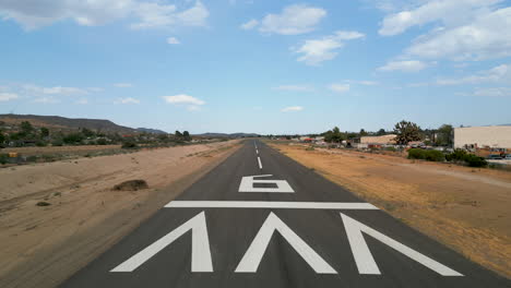 aerial drone shot traveling down the runway at a small general aviation airport