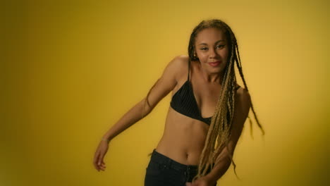 dancer girl dancing in studio with yellow wall. african woman dancing