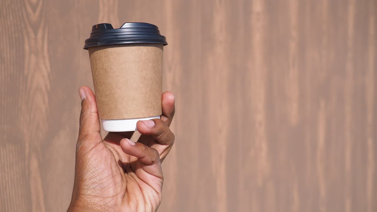 Hand holding a takeaway coffee cup