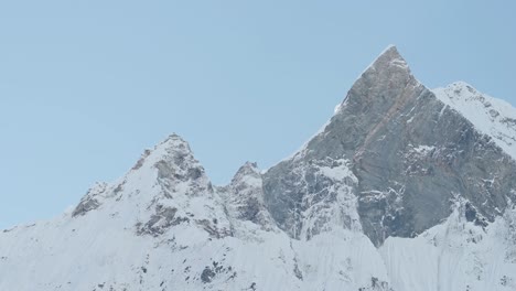 massive minimal blue winter mountain top in himalayas mountains in nepal, minimalist white and blue mountain summit, close up big large pointy pointed mountain peak