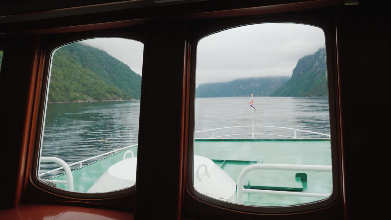 ver a través del ojo de buey del barco al pintoresco fiordo noruego 4k video