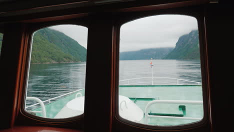 view through the porthole of the ship to the picturesque norwegian fjord 4k video