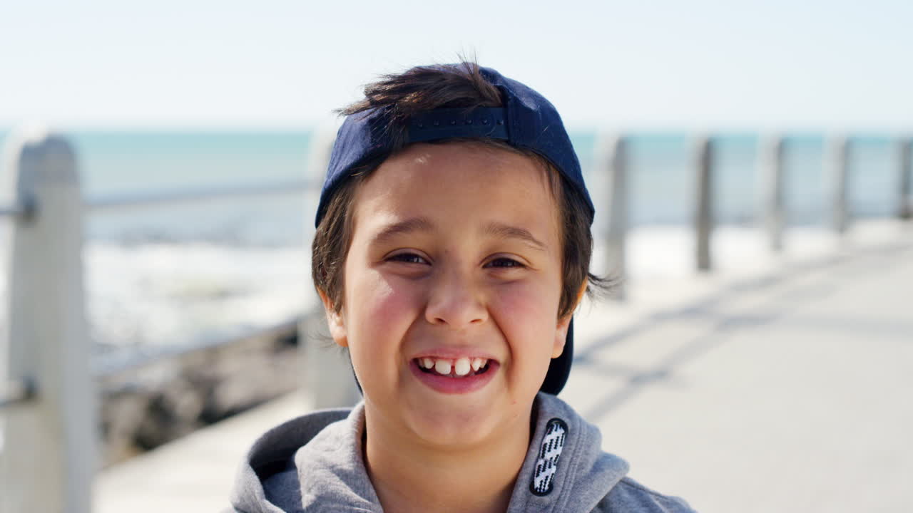 cara, sonrisa y niño feliz en la playa de vacaciones
