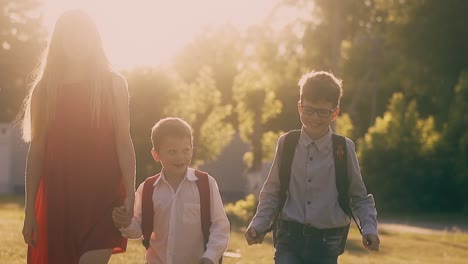 schoolboys-and-beautiful-woman-in-red-walk-after-lessons