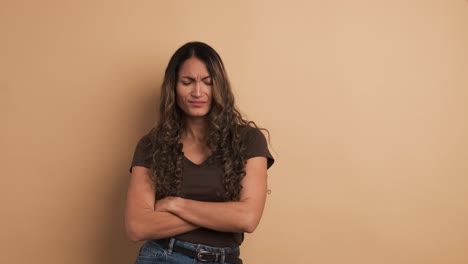 an hispanic woman upset standing crossing arms