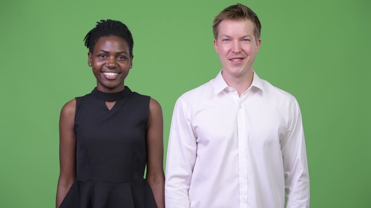 Two young multi-ethnic business couple smiling together