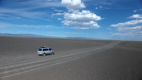 aerial drone shot following a van in the desert mongolia