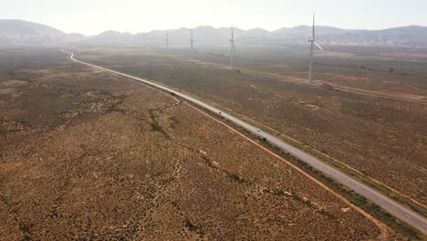 Aerial-drone-landscape-shot-of-cars-on-freeway-highway-Flinders-Ranges-wind-solar-farm-travel-tourism-climate-change-Port-Augusta-Adelaide-South-Australia-4K