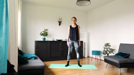 young girl doing her workout at home in the living room - lunge squat exercise