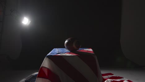 low key lighting studio shot of american football on stars and stripes flag 6