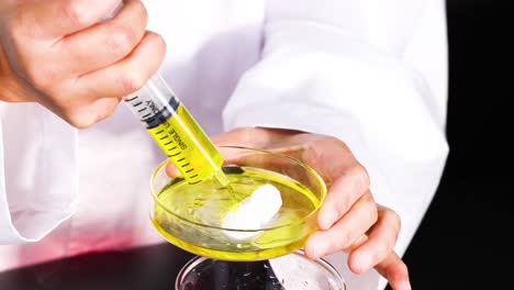 scientist injecting liquid into a petri dish