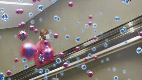 animation of covid 19 cells over african american man on escalator wearing face mask