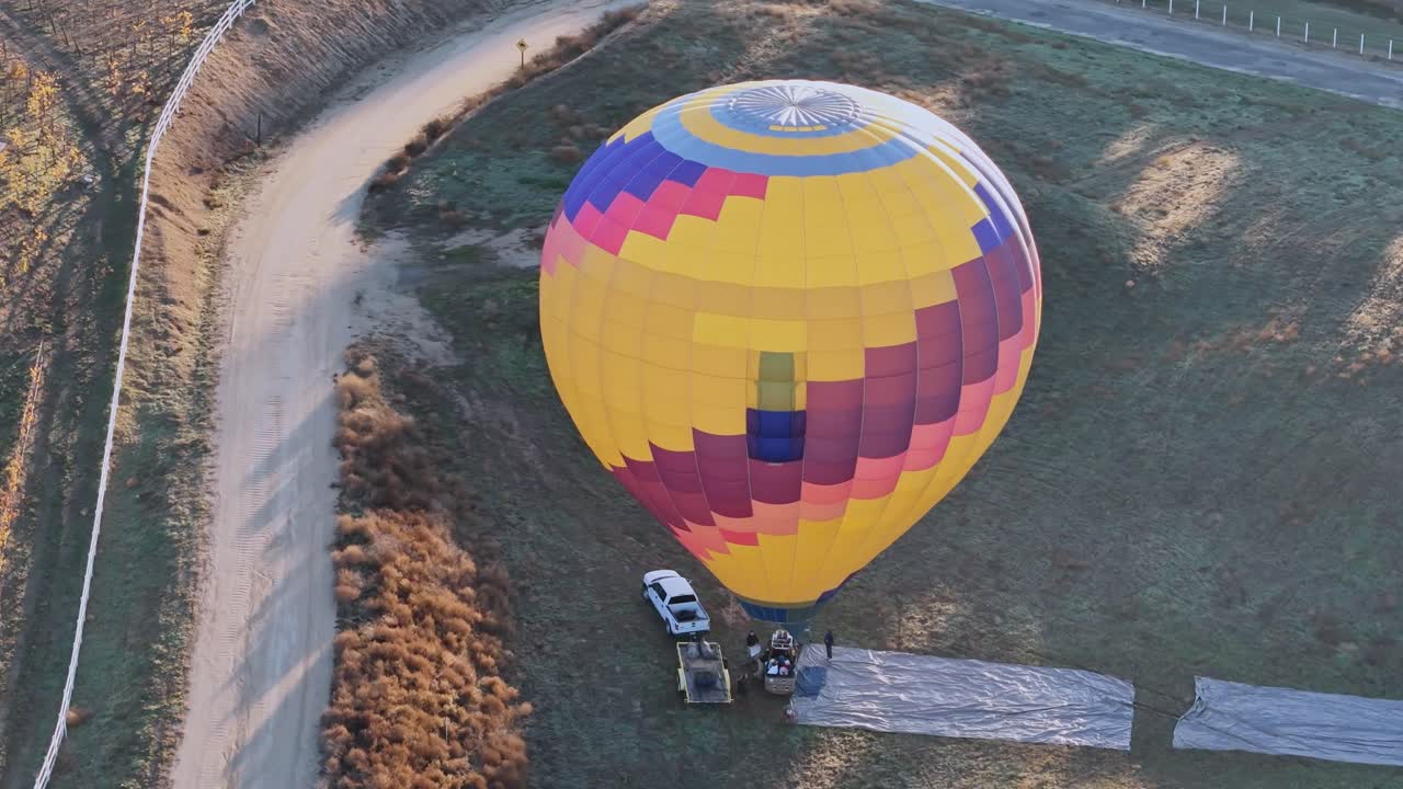 Mongolfiera di Temecula pronta al lancio con passeggeri a bordo, mentre un drone sorvola poco dopo l'alba.