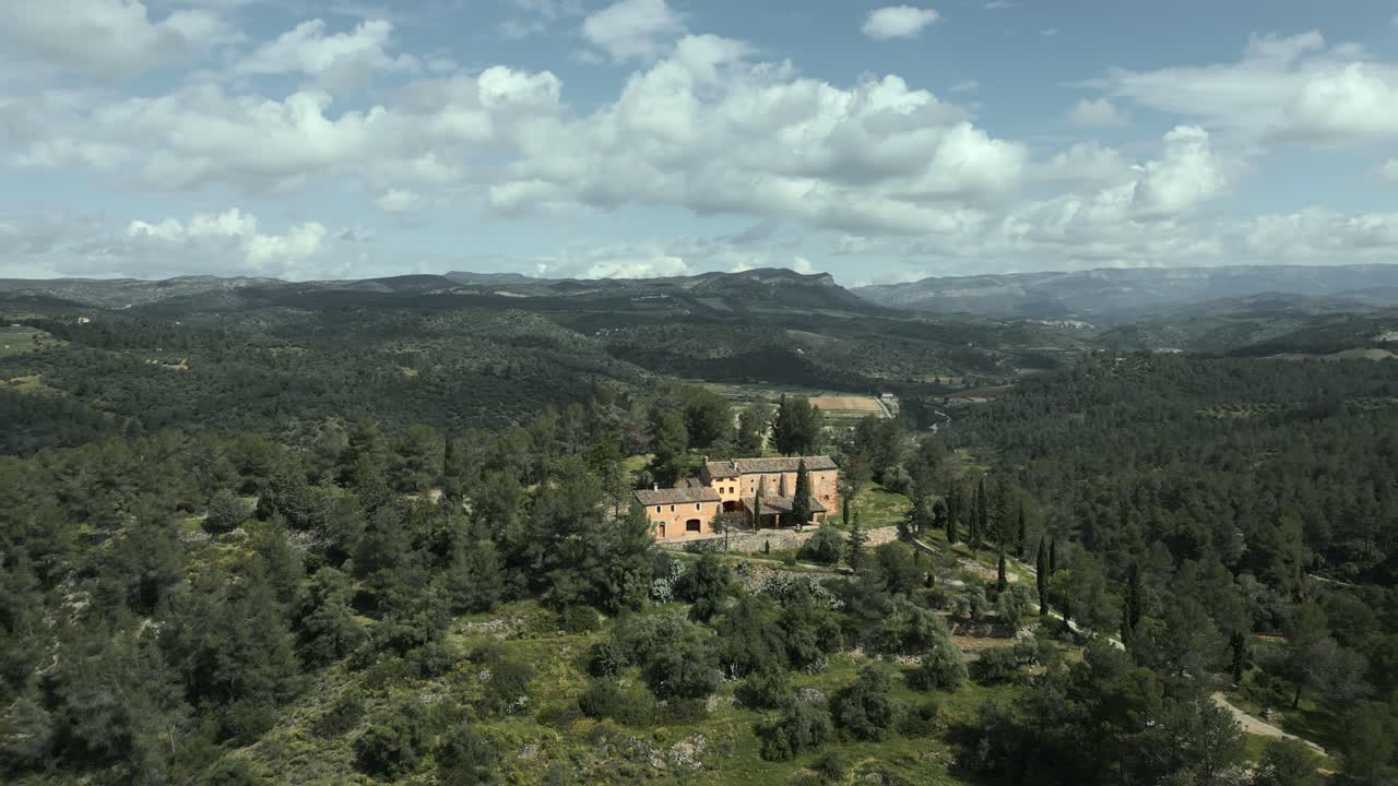 Aerial view of picturesque catalan hermitage mare de deu de pinyeres nestling amid serene el priorat landscape, revealing tranquil beauty under bright blue sky