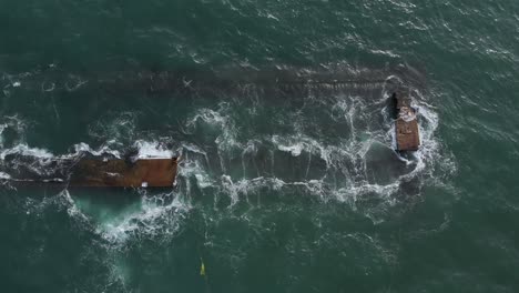 Vertical-aerial-footage-of-waves-over-the-dredger-ship-after-excavating-material-from-the-sea-bed