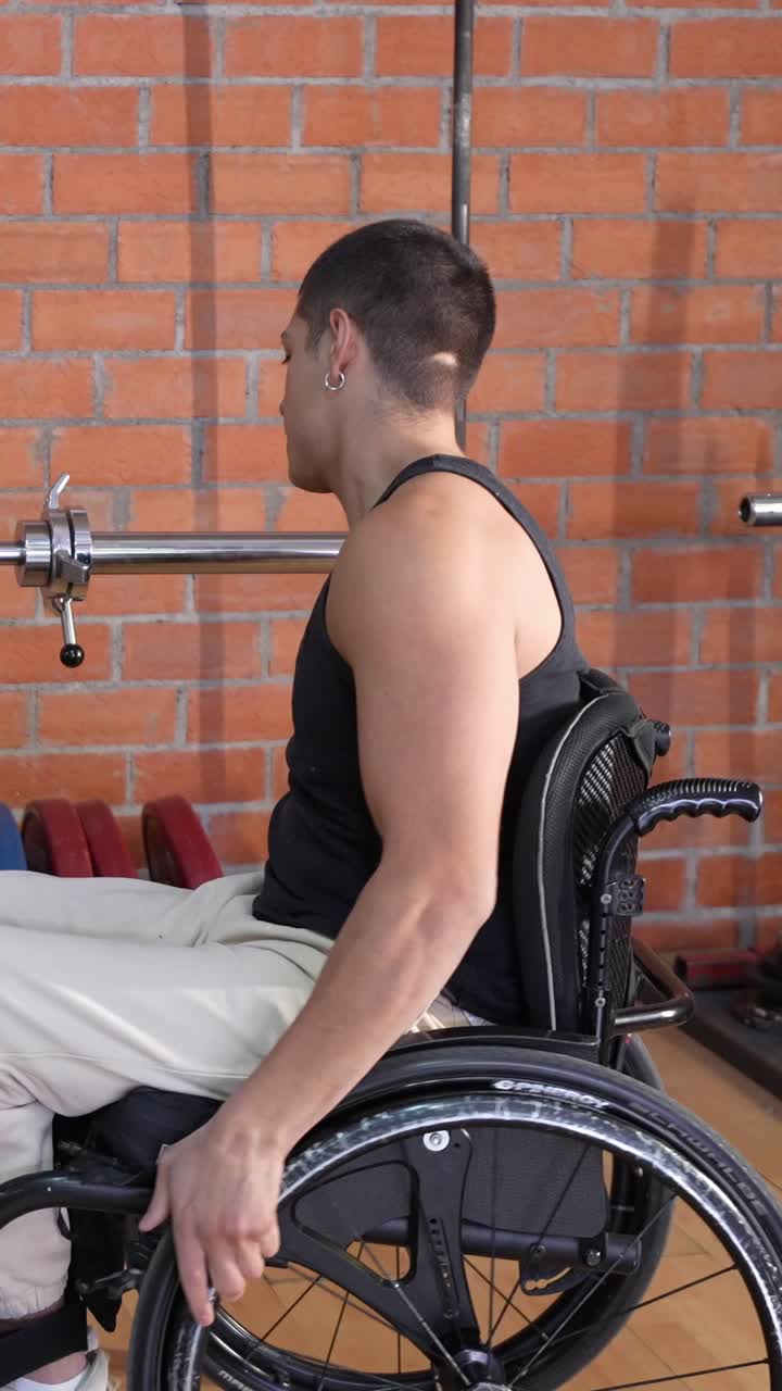 Giovane uomo in sedia a rotelle che sistema i pesi del bilanciere in palestra