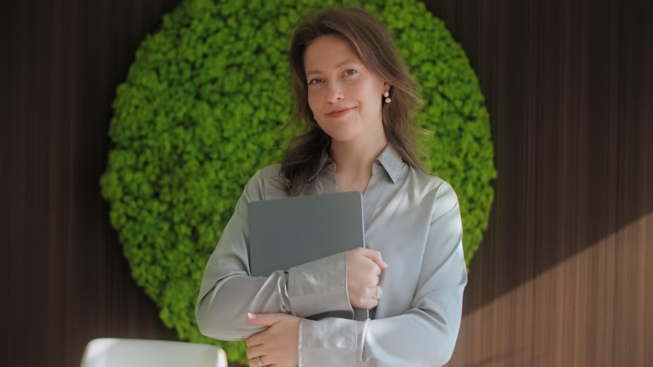 Business Woman Holding Laptop in Modern Office