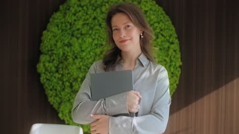 business woman holding laptop in modern office
