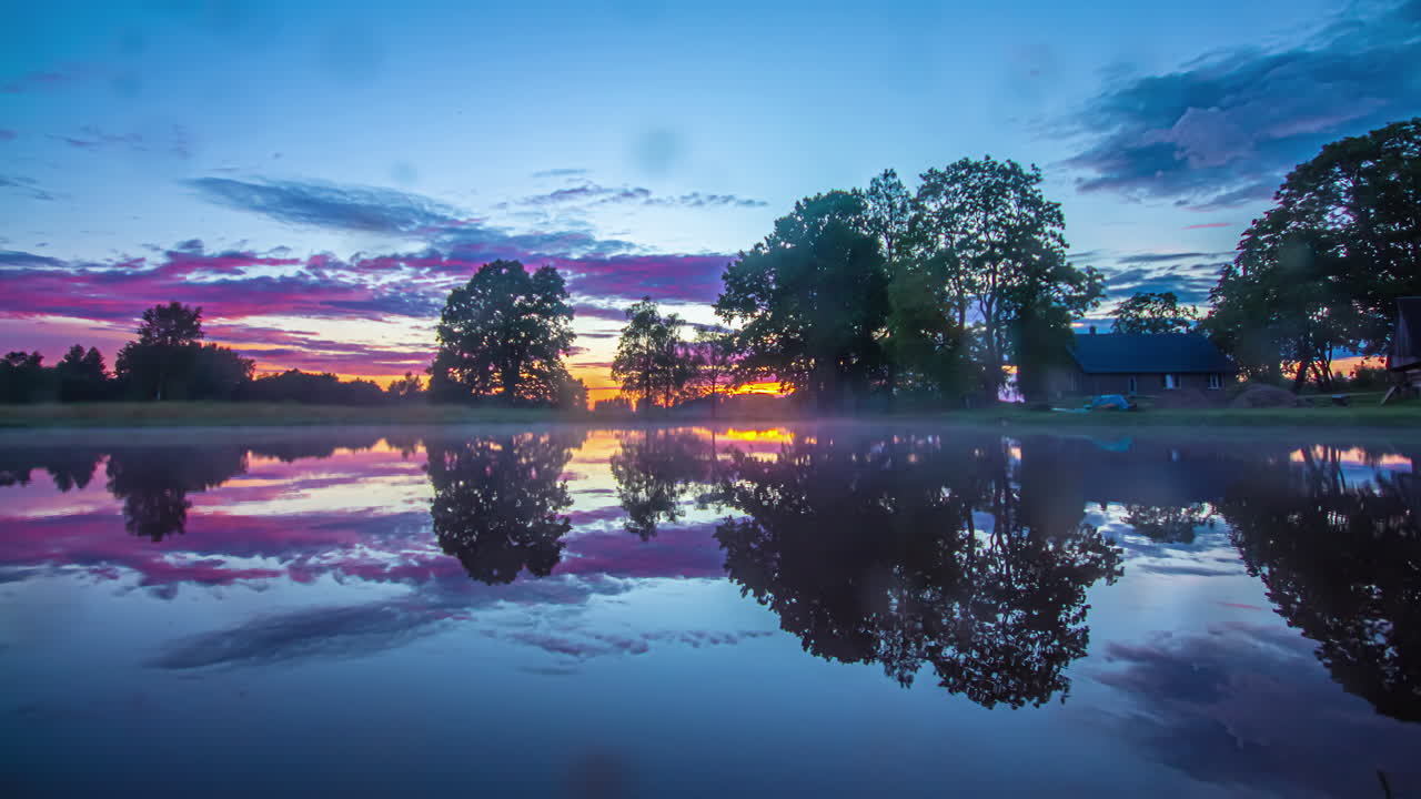 потрясающий закат, отражающийся от озера у загородного дома - time lapse