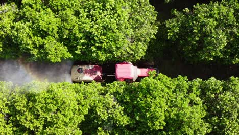 close up drone shot following tractor spraying chemicals on farmland