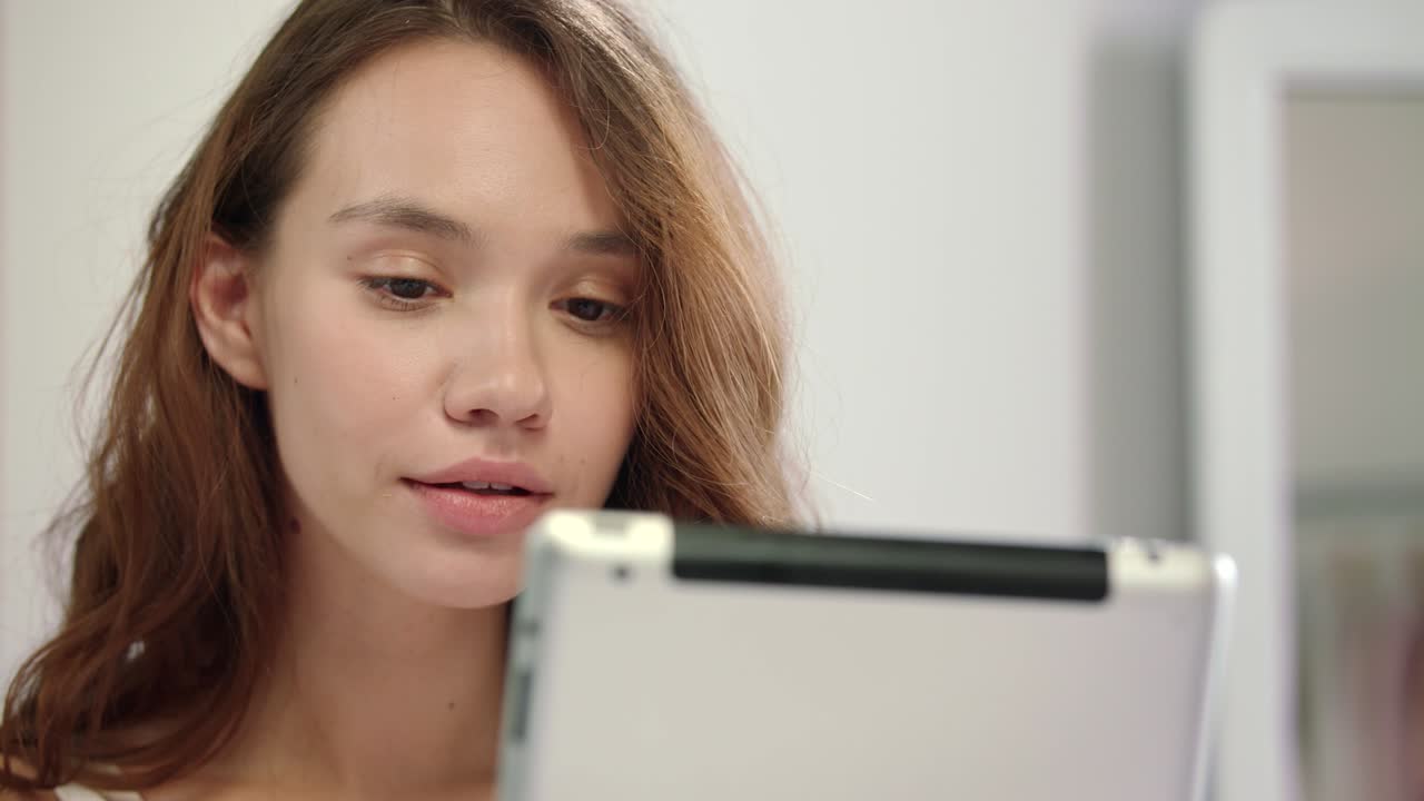 태블릿을 사용하는 웃는 여자. 태블릿 컴퓨터와 함께 웃는 행복한 여자