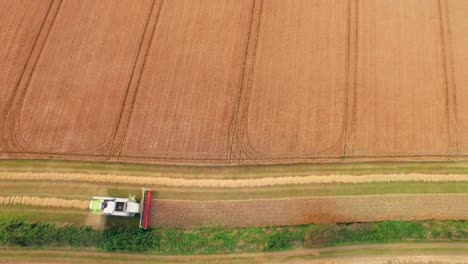 drone footage of golden fields and combine harvester