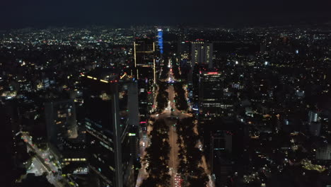 Aerial-scenic-view-of-night-cityscape-from-descending-drone.-Wide-street-illuminated-by-streetlights.--Mexico-city,-Mexico.