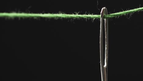 video de micro de hilo verde que pasa a través de la aguja con espacio de copia en fondo negro