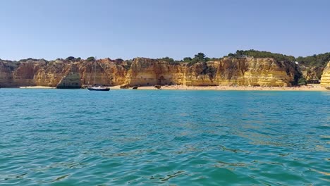 yacht sailing along the rocky coast of the algarve